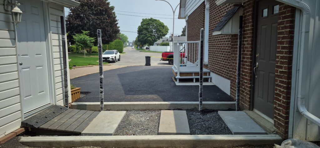 Aménagement extérieur à Laval avec balcon, rampes, béton, crépi et asphalte