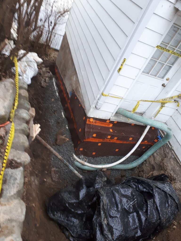 Fondation reconstruite avec membranes de protection et système de drainage à Laval